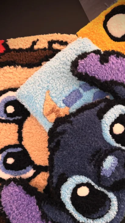 Varios tapetes de tufting de Bruma apilados: Stitch, un perro y otros diseños