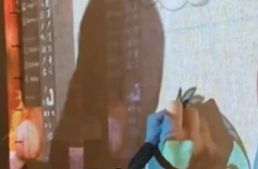 Artista de Bruma trazando un diseño de Stitch proyectado sobre la tela de tufting