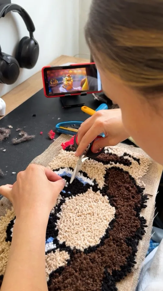 Artista de Bruma recortando a mano un tapete de Mario Bros en su taller